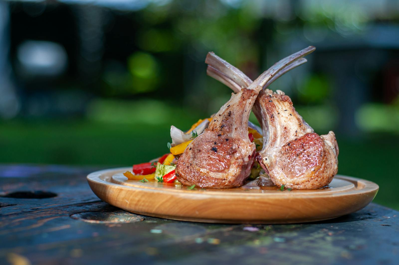 Wooden Plate of Roasted Lamb Chops with Vegetables
